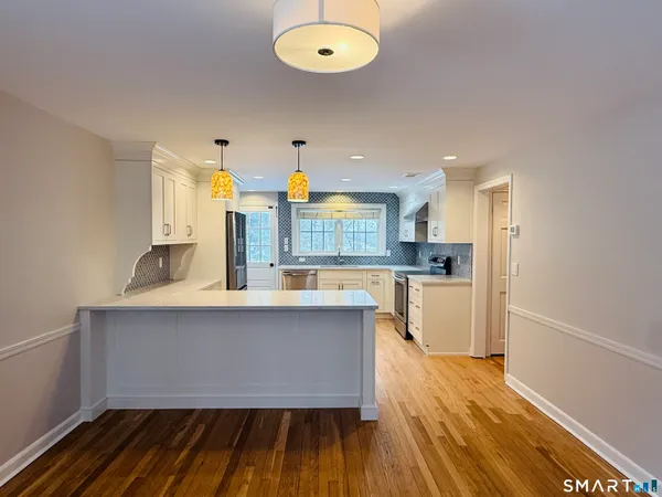 a kitchen with wooden floor and window