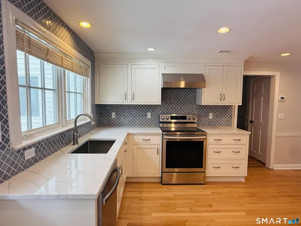 a kitchen with stainless steel appliances granite countertop a sink stove and refrigerator