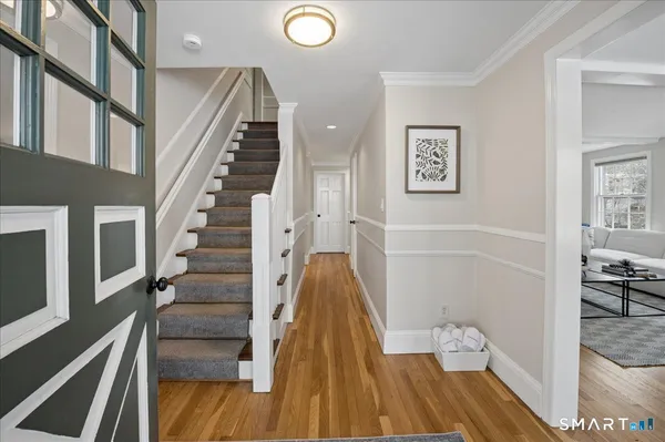 a view of a hallway with wooden floor and staircase