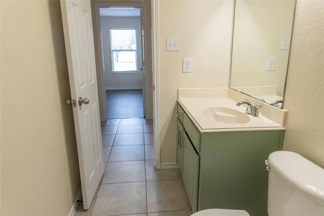 a bathroom with a granite countertop bathtub shower sink vanity and toilet