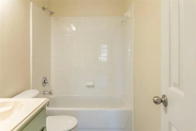 a view of an empty room with wooden floor and closet