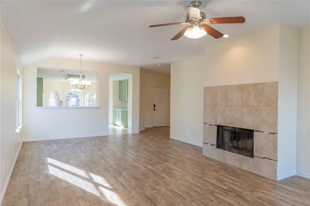 a view of an empty room with window and wooden floor