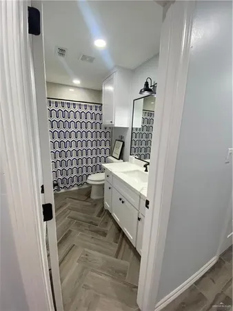 a bathroom with a double vanity sink toilet and shower
