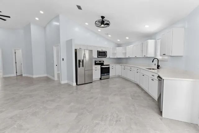 a large kitchen with cabinets and stainless steel appliances