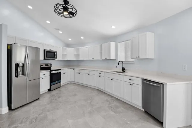 a large kitchen with cabinets stainless steel appliances and a counter space