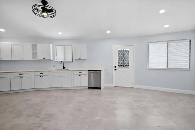 a large white kitchen with cabinets