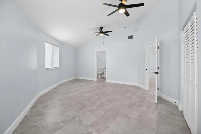 an empty room with a window and a ceiling fan