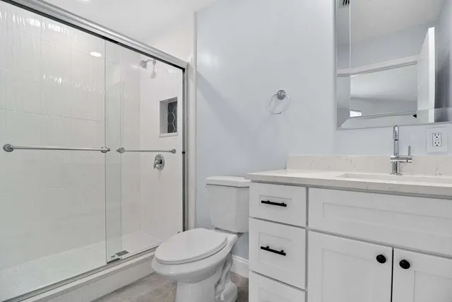 a bathroom with a sink a toilet and shower