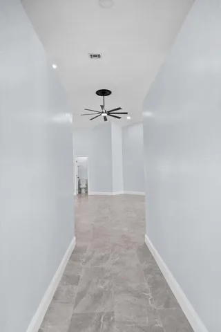 a view of a hallway with a chandelier fan