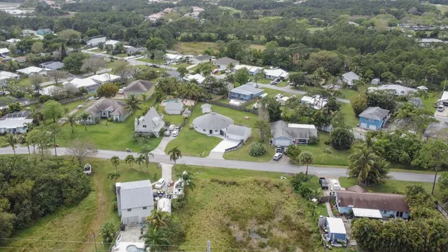 an aerial view of residential houses with outdoor space and trees