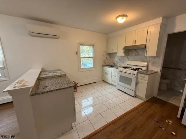 a kitchen with granite countertop a sink stove and refrigerator