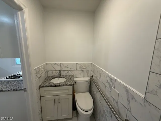 a bathroom with a granite countertop toilet and a sink