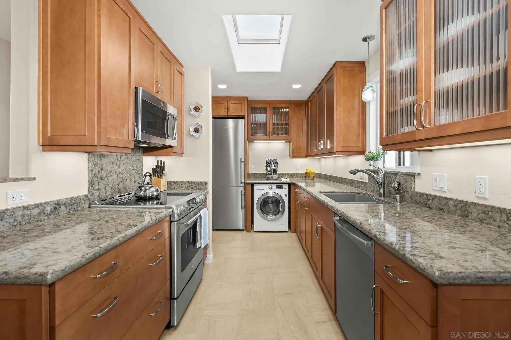 429 South Sierra Avenue, Unit 328 Solana Beach, CA 92075 - Photo 24 of 43 a kitchen with stainless steel appliances granite countertop a sink a stove and a microwave