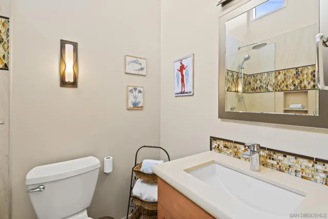 a bathroom with a sink vanity mirror and toilet