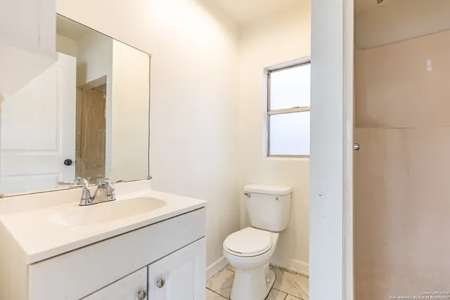 a bathroom with a sink a toilet and mirror