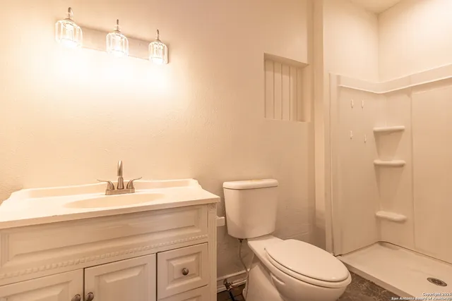 a bathroom with a sink a toilet and shower