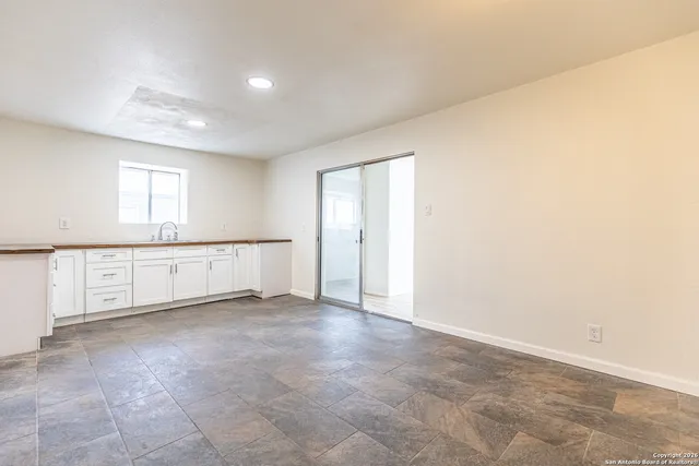 an empty room with windows and cabinet