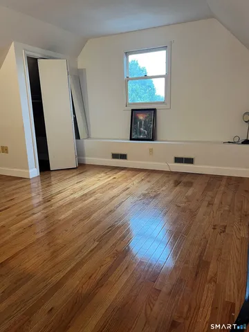 an empty room with wooden floor and a window