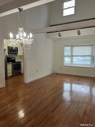 a view of a room with wooden floor and chandelier