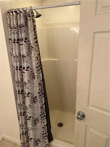 a bathroom with a shower curtain and toilet