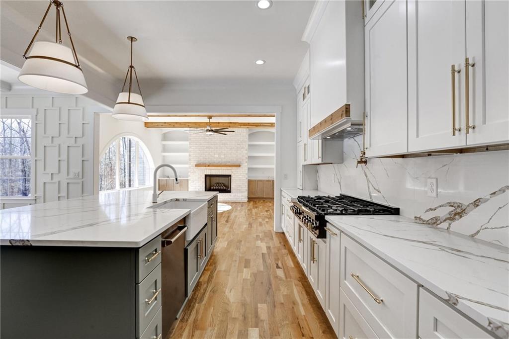 6113 Deepwater Cove Gainesville, GA 30506 - Photo 14 of 82 a kitchen with granite countertop a sink a stove top oven a counter space and cabinets