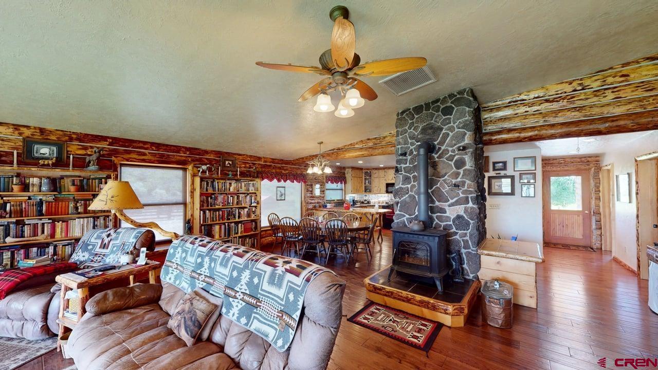 11694 Trap Club Road Austin, CO 81410 - Photo 12 of 45 a living room with furniture a bookshelf and a chandelier
