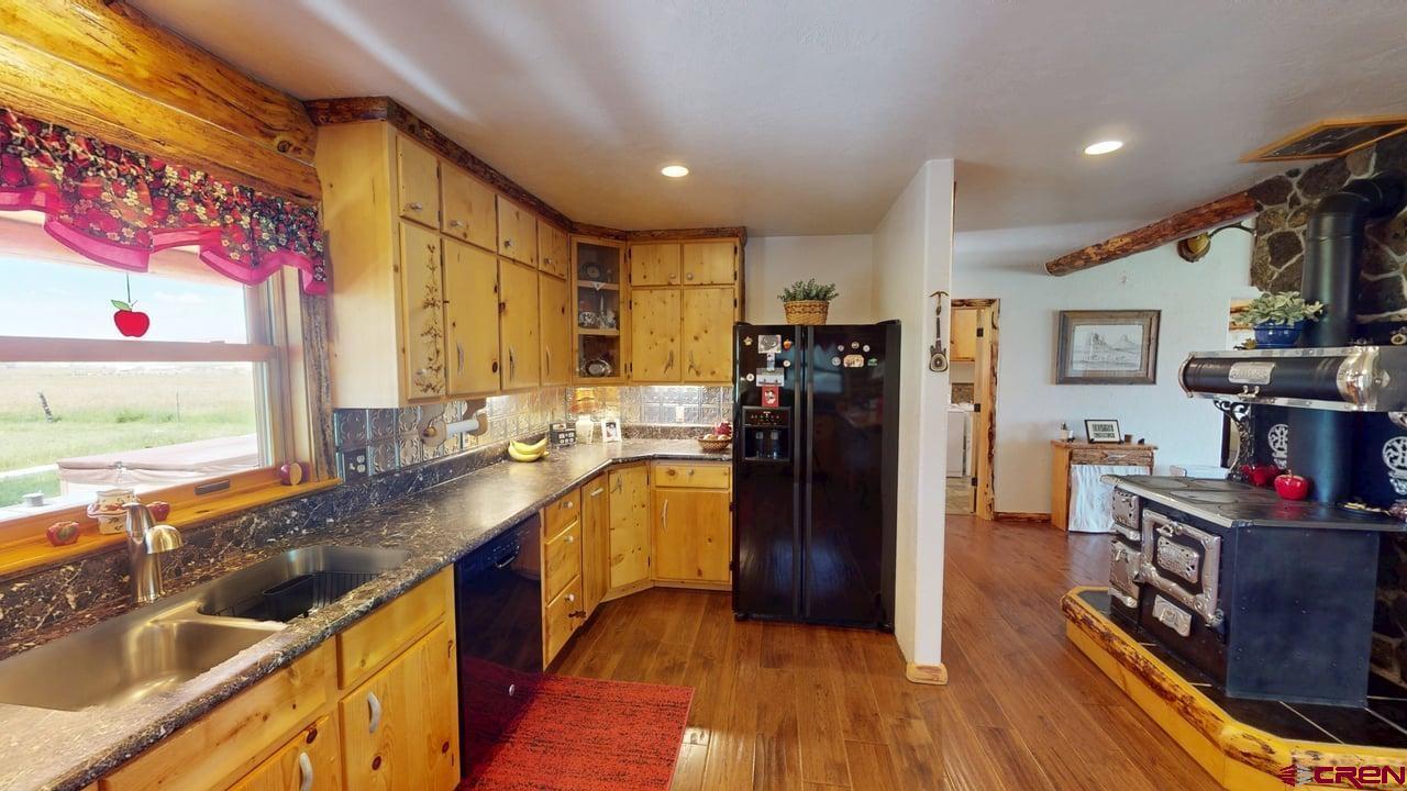 11694 Trap Club Road Austin, CO 81410 - Photo 14 of 45 a kitchen with stainless steel appliances granite countertop a refrigerator and a sink