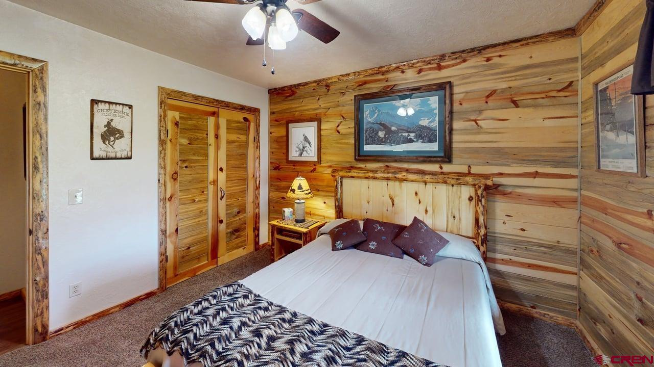 11694 Trap Club Road Austin, CO 81410 - Photo 19 of 45 a bedroom with a bed and a chandelier