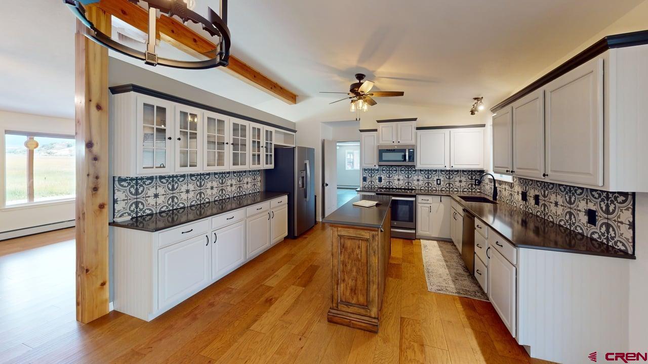 11694 Trap Club Road Austin, CO 81410 - Photo 24 of 45 a large kitchen with stainless steel appliances granite countertop a stove and a wooden floors
