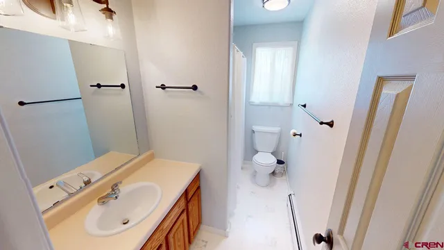 a bathroom with a sink a toilet and shower curtain