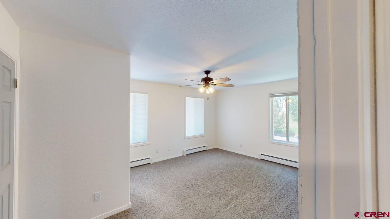 11694 Trap Club Road Austin, CO 81410 - Photo 28 of 45 an empty room with windows and fan
