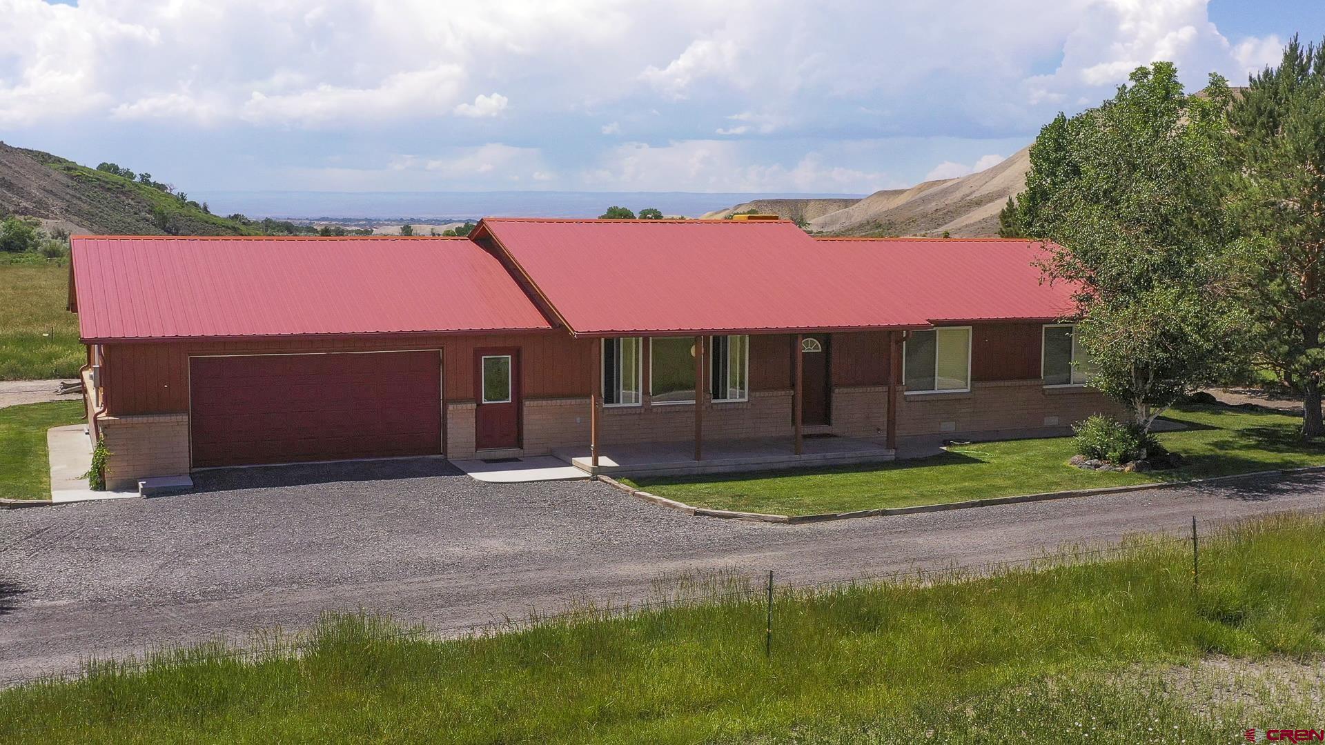 11694 Trap Club Road Austin, CO 81410 - Photo 7 of 45 a front view of a house with a yard and garage