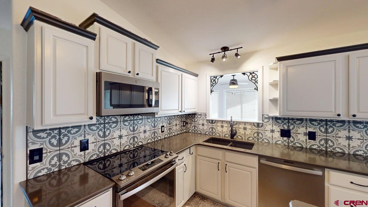 11694 Trap Club Road Austin, CO 81410 - Photo 10 of 45 a kitchen with stainless steel appliances a sink stove and cabinets
