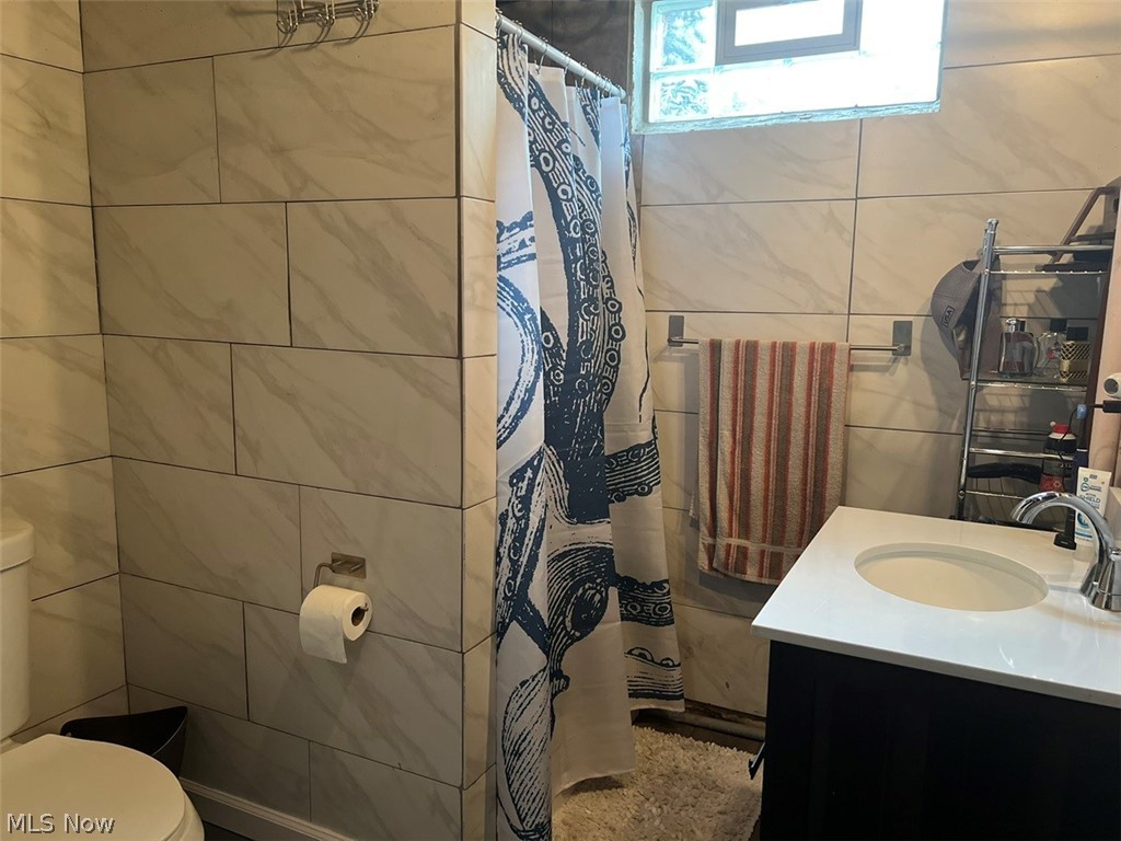 759 Truesdale Road Youngstown, OH 44511 - Photo 27 of 37 Bathroom with vanity, toilet, and tile walls
