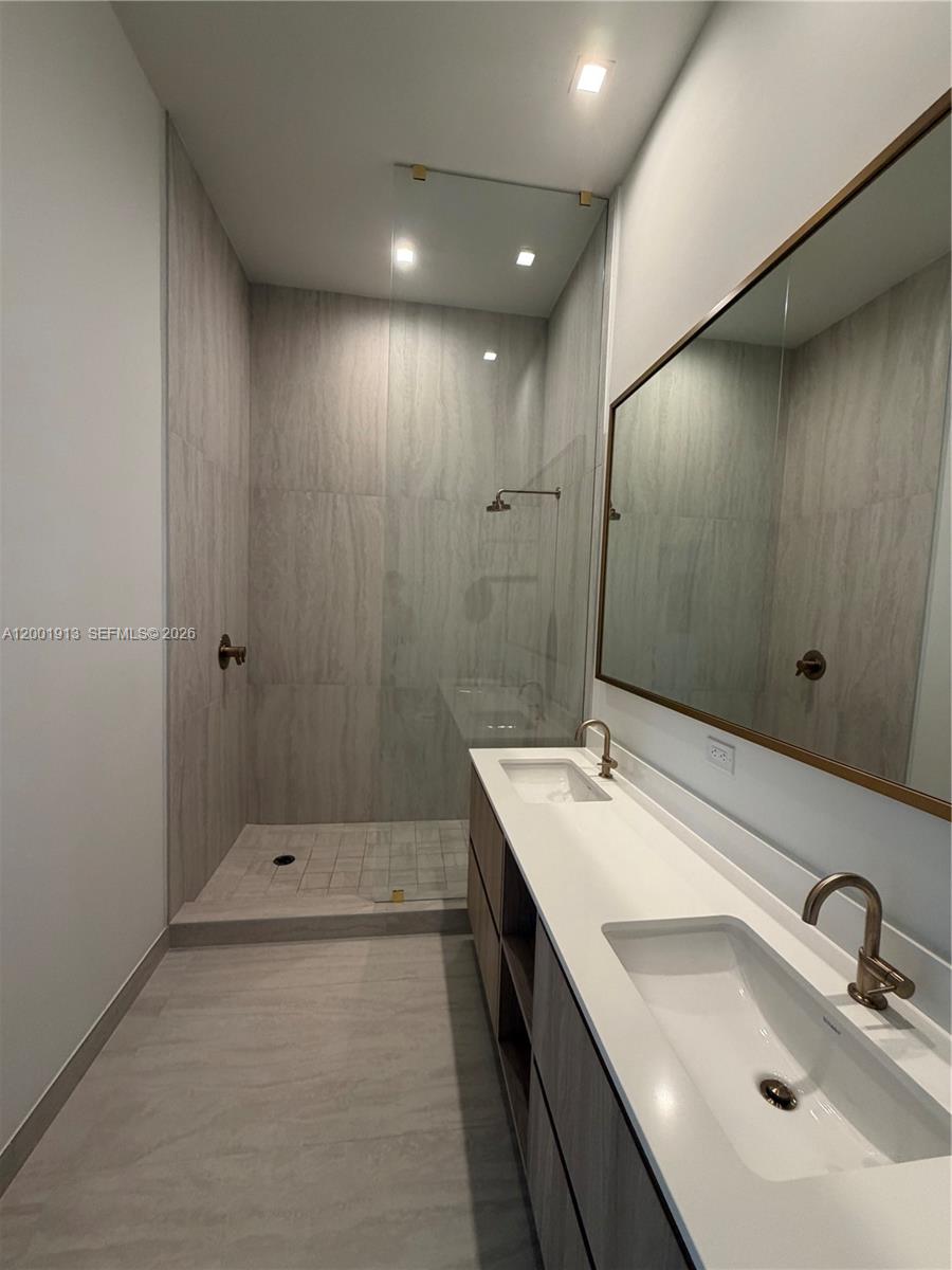 77 Southeast 5th Street, Unit 1007 Miami, FL 33131 - Photo 6 of 31 a bathroom with a sink and mirror