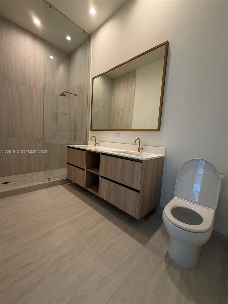 77 Southeast 5th Street, Unit 1007 Miami, FL 33131 - Photo 7 of 31 a bathroom with a sink toilet and mirror