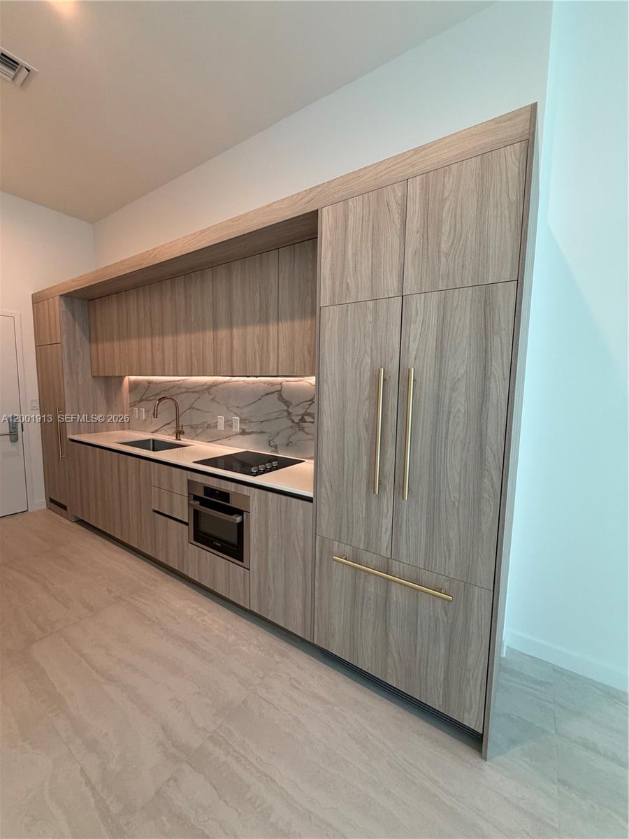 77 Southeast 5th Street, Unit 1007 Miami, FL 33131 - Photo 9 of 31 a kitchen with appliances and cabinets