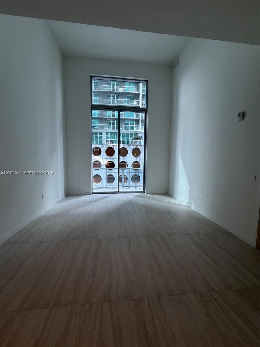 77 Southeast 5th Street, Unit 1007 Miami, FL 33131 - Photo 10 of 31 a view of a livingroom with wooden floor and a window