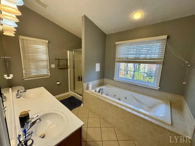 a en suite bathroom with a granite countertop tub and a sink