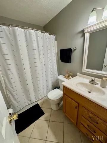 a bathroom with a granite countertop sink toilet and a mirror