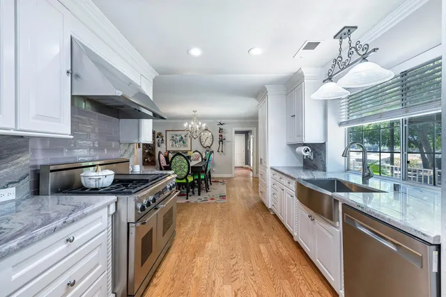 a large kitchen with stainless steel appliances granite countertop a lot of counter space and a large window