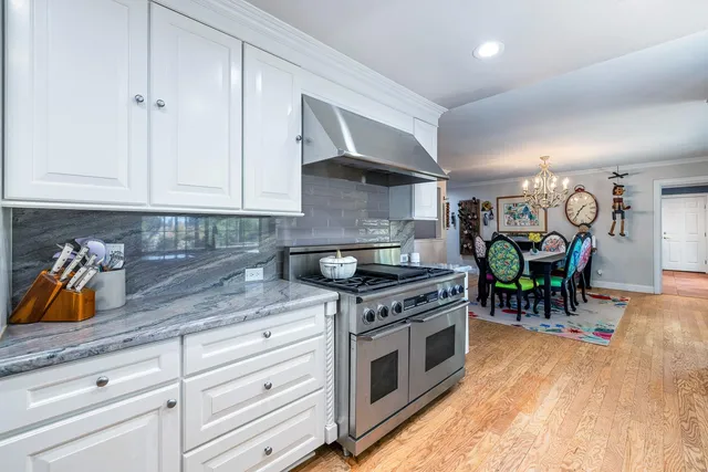 a kitchen with kitchen island granite countertop stainless steel appliances and wooden cabinets