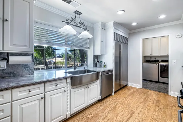 a kitchen with stainless steel appliances granite countertop a stove a sink and a microwave
