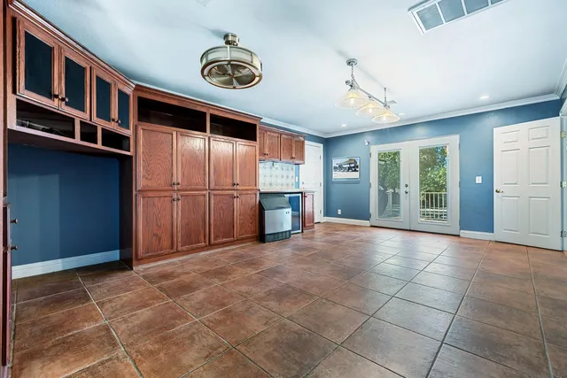 a view of an empty room with wooden floor and a ceiling fan