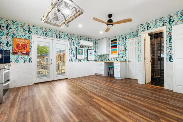 a kitchen with stainless steel appliances a stove top oven a sink a window and white cabinets