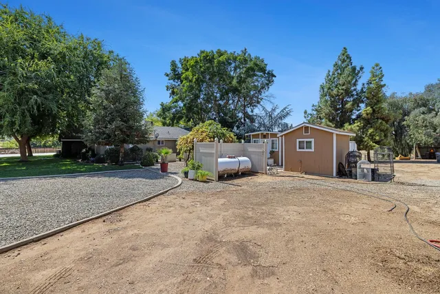 a view of a house with a yard and large tree