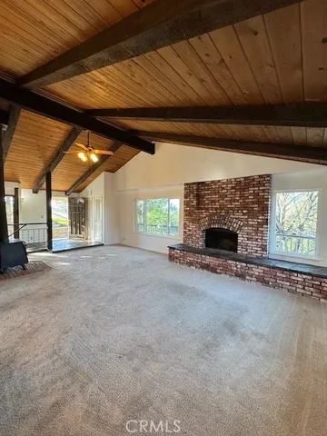 a view of an empty room with a fireplace and a window