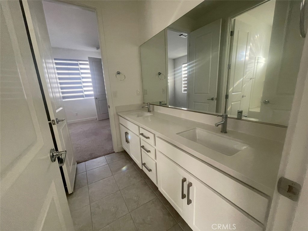 170 Episode Irvine, CA 92618 - Photo 33 of 63 a bathroom with a double vanity sink a mirror and a shower