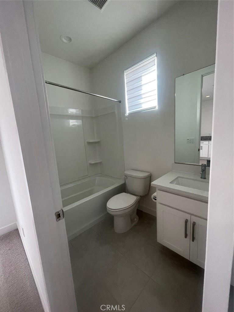 170 Episode Irvine, CA 92618 - Photo 36 of 63 a bathroom with a granite countertop toilet a sink a mirror and shower