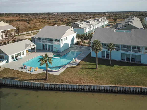 an aerial view of residential houses with outdoor space and ocean view